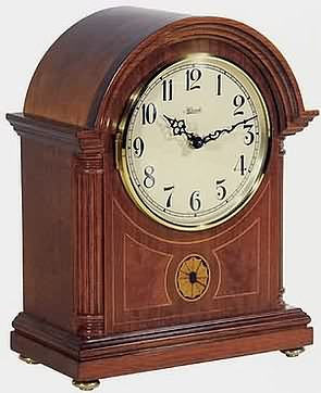 Hermle 22827-072115 Barrister II Chiming Mantel Clock Elegant Barrister style mantle clock made from select hardwoods in a rich Cherry finish with an ivory dial and filigree hands.    The front panel features exquisite inlaid marquetry . German...